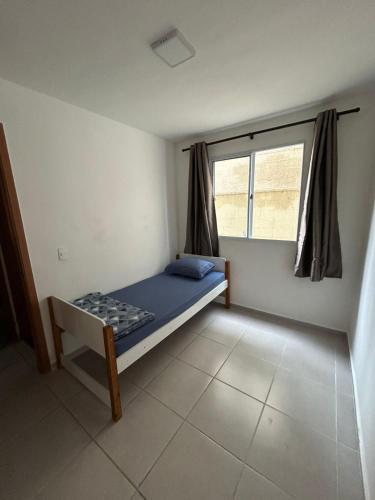 a small room with a bed and a window at Apartamento Aconchego in Botucatu