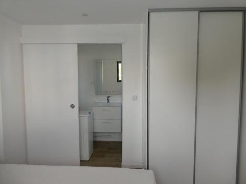 une chambre avec des murs blancs et un miroir dans l'établissement Les Amarres, maison bois avec terrasse proche mer, à La Rochelle