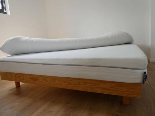 un matelas posé sur un banc en bois dans l'établissement Les Amarres, maison bois avec terrasse proche mer, à La Rochelle