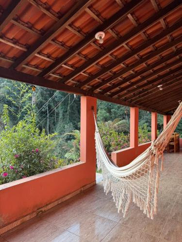 una hamaca en el porche de una casa en Hostel da Verinha, en Itamonte