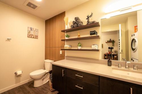 a bathroom with a toilet and a sink and a mirror at Heart of Downtown Apt with City View, Walkable to HotSpots in Spokane