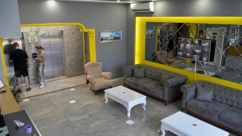 een woonkamer met 2 banken en een gele muur bij Skyport Istanbul in Istanbul