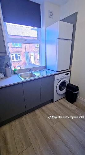 a kitchen with a sink and a washing machine at Dress to impress home in Amley