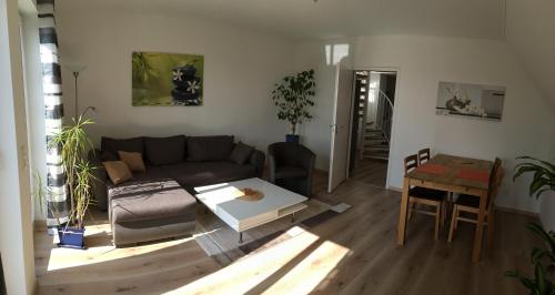 ein Wohnzimmer mit einem Sofa und einem Tisch in der Unterkunft Ferienwohnung am Golfplatz in Ullersdorf