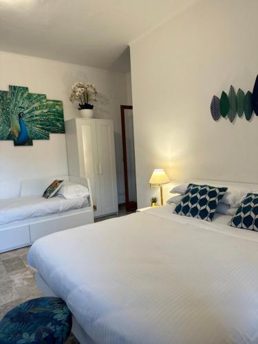 une chambre avec un grand lit blanc et un canapé dans l'établissement Penthouse Salus sea view terrace, à Lido di Ostia