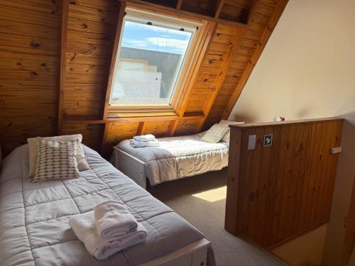 ein Schlafzimmer mit zwei Betten und einem Fenster in der Unterkunft Paimun 2 - Andarlibre in San Martín de los Andes