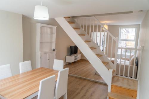 ワーキントンにあるYour Perfect Home Away From Homeのテーブルと階段のあるキッチンとダイニングルーム