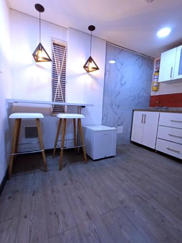 a kitchen with two stools and a table in a room at Hotel Boutique CGH Aeropuerto in Bogotá