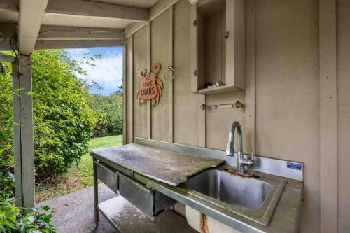 a kitchen with a sink and an open door at Twin Rocks Hideaway in Rockaway Beach