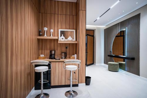 a bar in a room with wooden walls and stools at شاليه مسا الفندقي in Buraydah