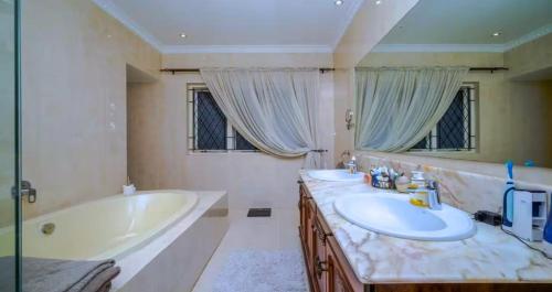 ダーバンにあるThe Greywoodのバスルーム(バスタブ、シンク2台、バスタブ付)