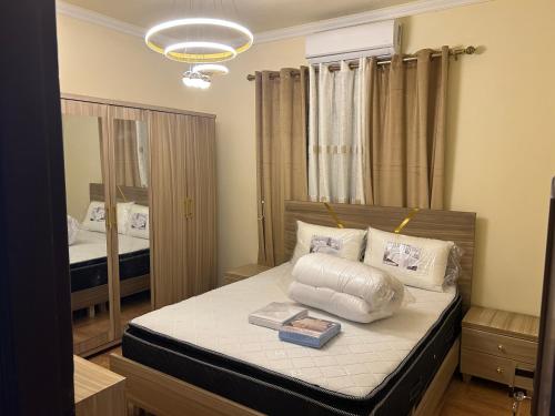 a bedroom with a bed with a pillow and books at Modern 3BR Sea & Mountain View Apartment Bouar, Keserwan in Bqāq ad Dīn