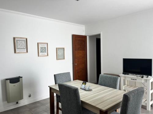a dining room with a table and chairs and a television at Hermoso PH en Necochea playa in Necochea