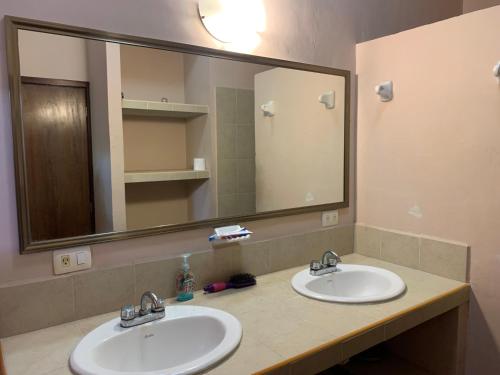 a bathroom with two sinks and a large mirror at Habitacion chica con piscina in Mérida