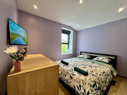a bedroom with a bed with a wooden dresser and a window at Le Spacieux gare d'Oullins - 2 chambres - 3 lits - Parking privé in Pierre-Bénite