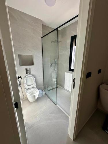 a bathroom with a toilet and a glass shower at Houseselect in Nador
