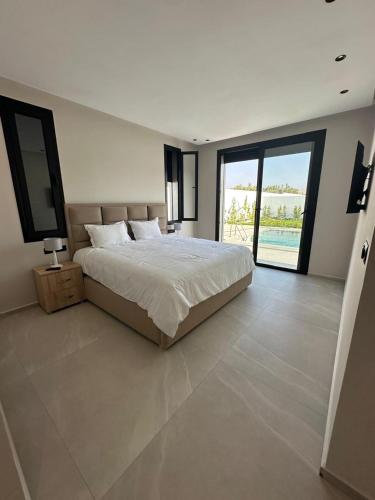 a bedroom with a large bed and a large window at Houseselect in Nador