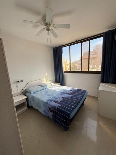 ein Schlafzimmer mit einem Bett und einem Deckenventilator in der Unterkunft Bel appartement Kikar Hatzmaout, centre et plage in Netanya
