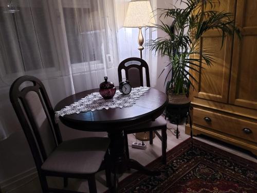 a dining room table with two chairs and a clock on it at Casa Cătălina in Silvaşu de Jos