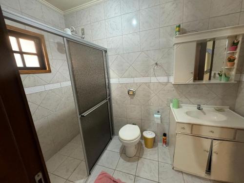 un bagno con doccia, WC e lavandino di Cód 16 - Casa a pouco a metros do mar a Governador Celso Ramos