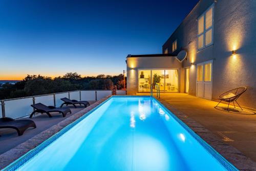 a swimming pool on the balcony of a house at MY DALMATIA - Sea view villa Anpero with private heated pool and sauna in Maslenica
