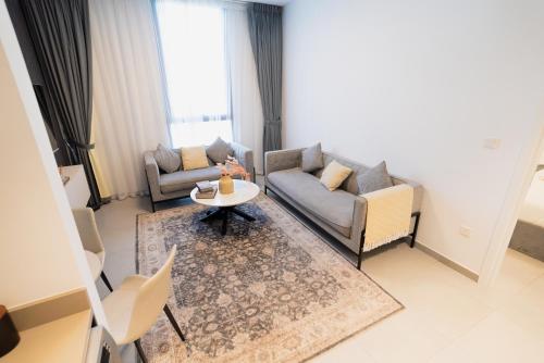 a living room with a couch and a table at One bedroom apartment in Sharjah by Stay Bnb in Sharjah