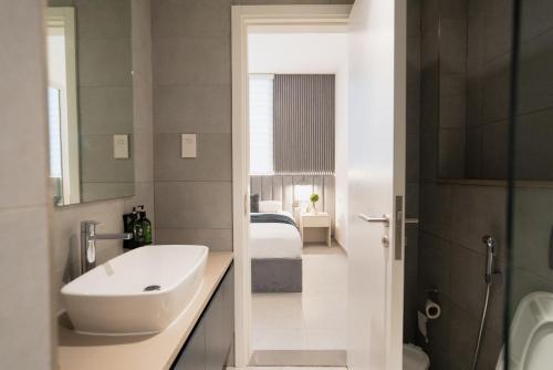 a bathroom with a sink and a toilet and a bedroom at One bedroom apartment in Sharjah by Stay Bnb in Sharjah