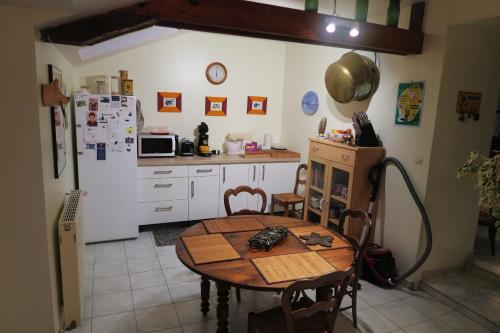 eine Küche mit einem Tisch und einem Kühlschrank in der Unterkunft Chez Hervé in Saint-Mars-sur-Colmont