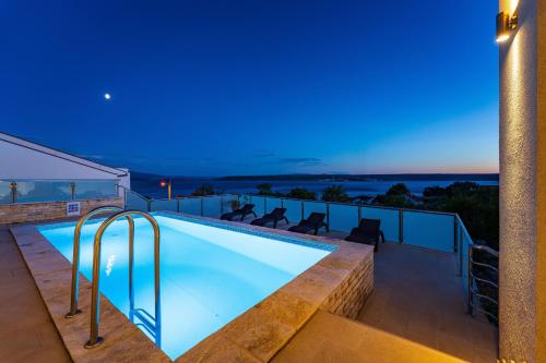 a swimming pool on the roof of a house at MY DALMATIA - Sea view villa Anpero with private heated pool and sauna in Maslenica