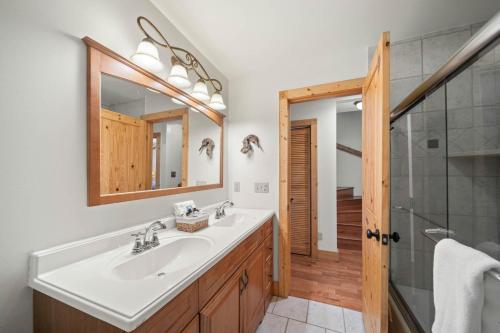 a bathroom with a sink and a shower and a mirror at Sit Stay Play in Beech Mountain