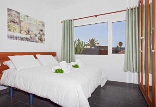 een slaapkamer met een bed en een groot raam bij Villa Esencia in Puerto del Carmen