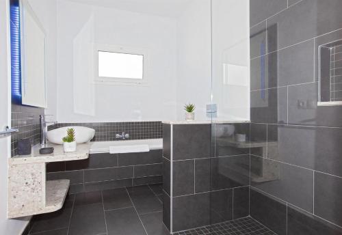 een badkamer met een wastafel en een ligbad bij Villa Esencia in Puerto del Carmen