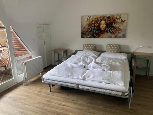 a bed in a bedroom with a painting on the wall at PEMATRA FeWo Kleine Brise in Travemünde