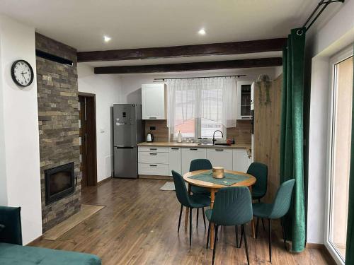 Una cocina y un comedor con mesa y sillas. en Relax house Tvarožec, 