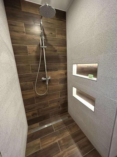 a bathroom with a shower with wooden tiles at Relax house Tvarožec in Vyšný Tvarožec