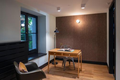 a room with a desk and a chair and a window at Hôtel Pax in Geneva
