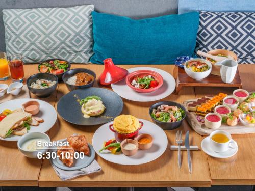 a wooden table with plates of food on it at Mitsui Garden Hotel Nagoya Premier in Nagoya