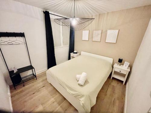 een slaapkamer met een wit bed en een spiegel bij Grand T2 au RDC hyper centre Navette et Sauna en option in Beauvais