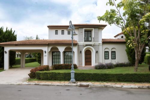 une maison blanche avec un panneau de rue devant dans l'établissement My Ozone Villa Khaoyai มายโอโซน วิลล่า เขาใหญ่, à Ban Sap Setthi