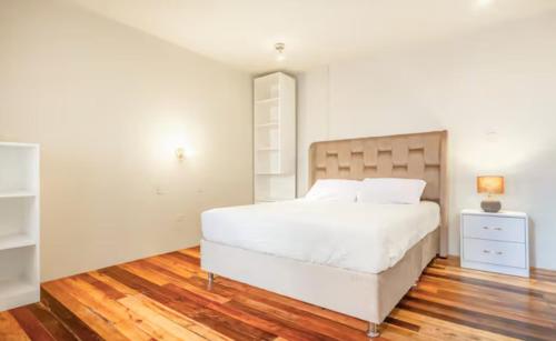 - une chambre avec un grand lit blanc et une table de nuit dans l'établissement Corazón de Cusco 2, à Cusco