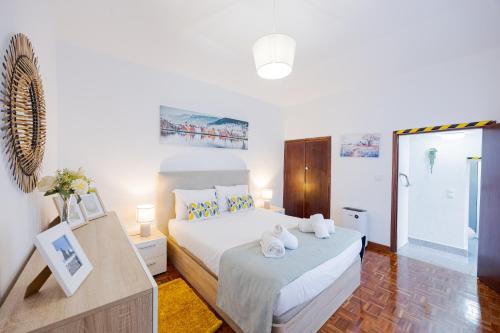 a white bedroom with a bed and a bathroom at Peaceful Panorama by YOUR KEY MADEIRA in Porto Moniz