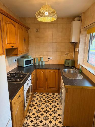 a kitchen with a sink and a stove top oven at Spacious 3 Bedroom House in Doncaster with Vintage Charm in Doncaster
