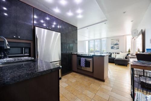 サンファンにあるAMARE Cozy Studio with Generator in Condadoのキッチン(黒いキャビネット付)、リビングルーム
