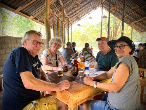 哈伯勒内Elephant Fence Habarana的坐在木桌旁的一群人