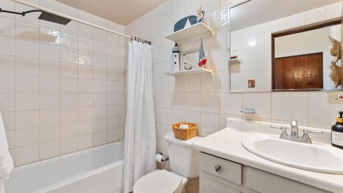 a bathroom with a sink and a tub and a toilet at Beachfront Serene Apt at Victoria del Mar 3F in Stella