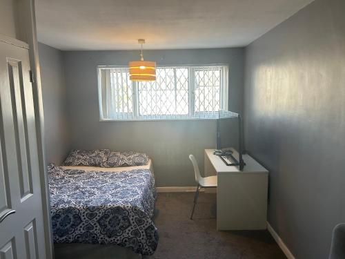 Un dormitorio con una cama y un escritorio y una ventana. en The Sawyers Court Home, en Chatham