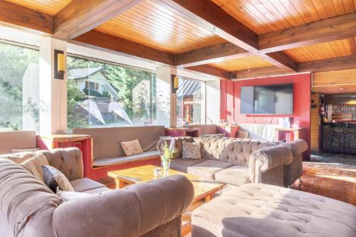 ein großes Wohnzimmer mit Sofas und Fernseher in der Unterkunft Hosteria de la Villa - Moonski in San Carlos de Bariloche