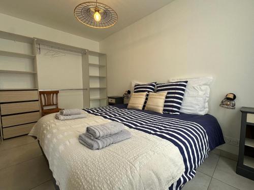een slaapkamer met een bed met handdoeken erop bij Chez Camille & Emma - Climatisé in Rochefort
