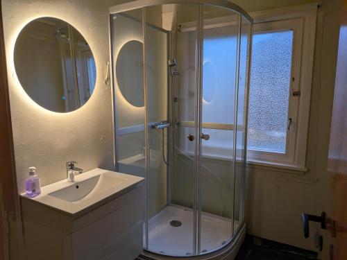 een badkamer met een glazen douche en een wastafel bij Aurora Seaview Escape E33 in Slåttvikstrand
