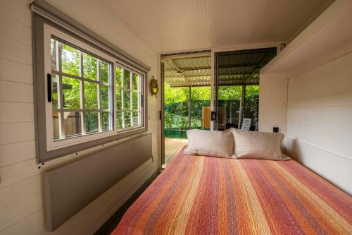 a bed in a room with a large window at Casa Playa Avellanas in Playa Avellana